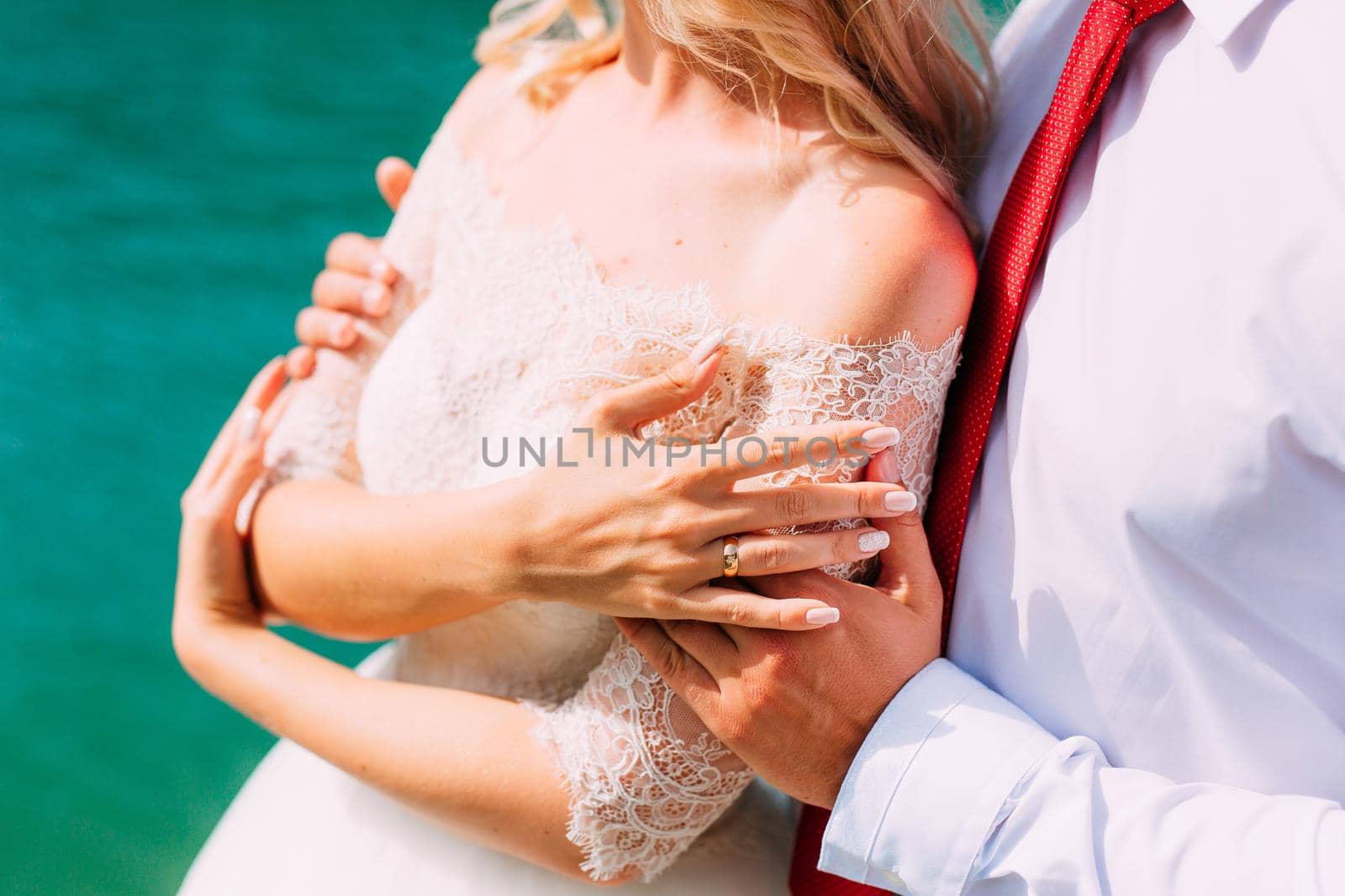 The groom embraces the bride on the beach. Wedding in Montenegro and Croatia.