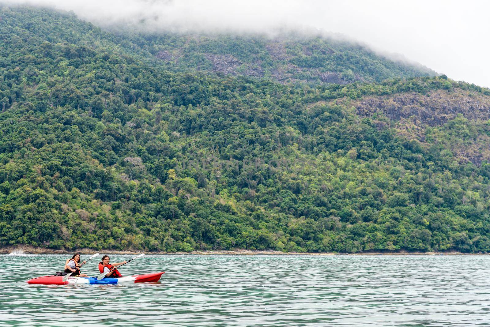 Two woman tourists are mother and daughter. Travel by boat with a kayak happy on the sea in the morning of summer at Ko Adang island is the background, Tarutao National Park, Satun, Thailand