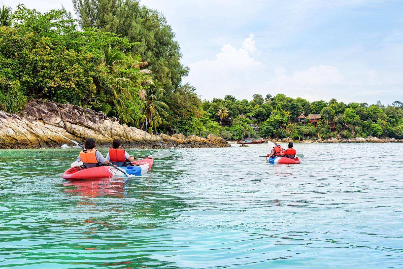 Tourist group are kayaking on the sea, travel by boat to see the beautiful nature landscape in the morning of summer at front the resort around Ko Lipe island, Tarutao National Park, Satun, Thailand