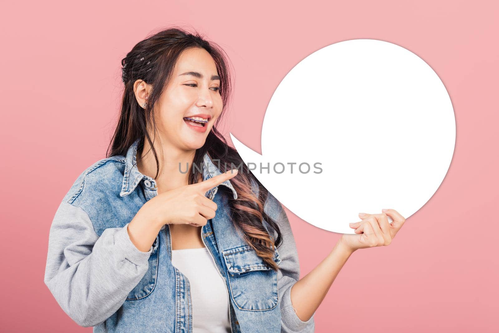 woman smiling excited wear denims hold empty speech bubble sign by Sorapop