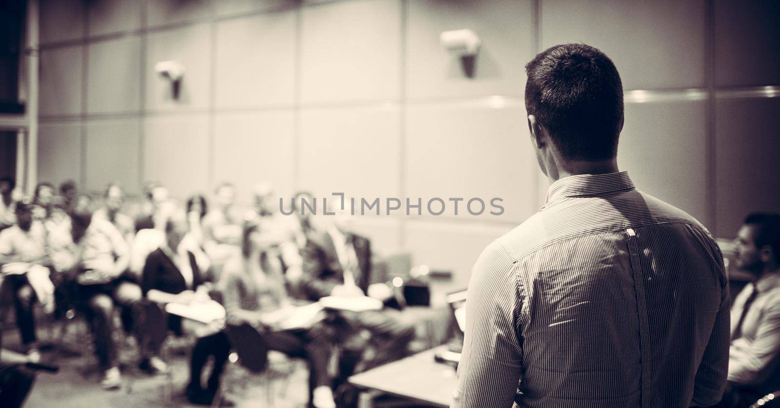 Speaker at Business Conference with Public Presentations. Audience at the conference hall. Entrepreneurship club. Rear view. Horisontal composition. Background blur.