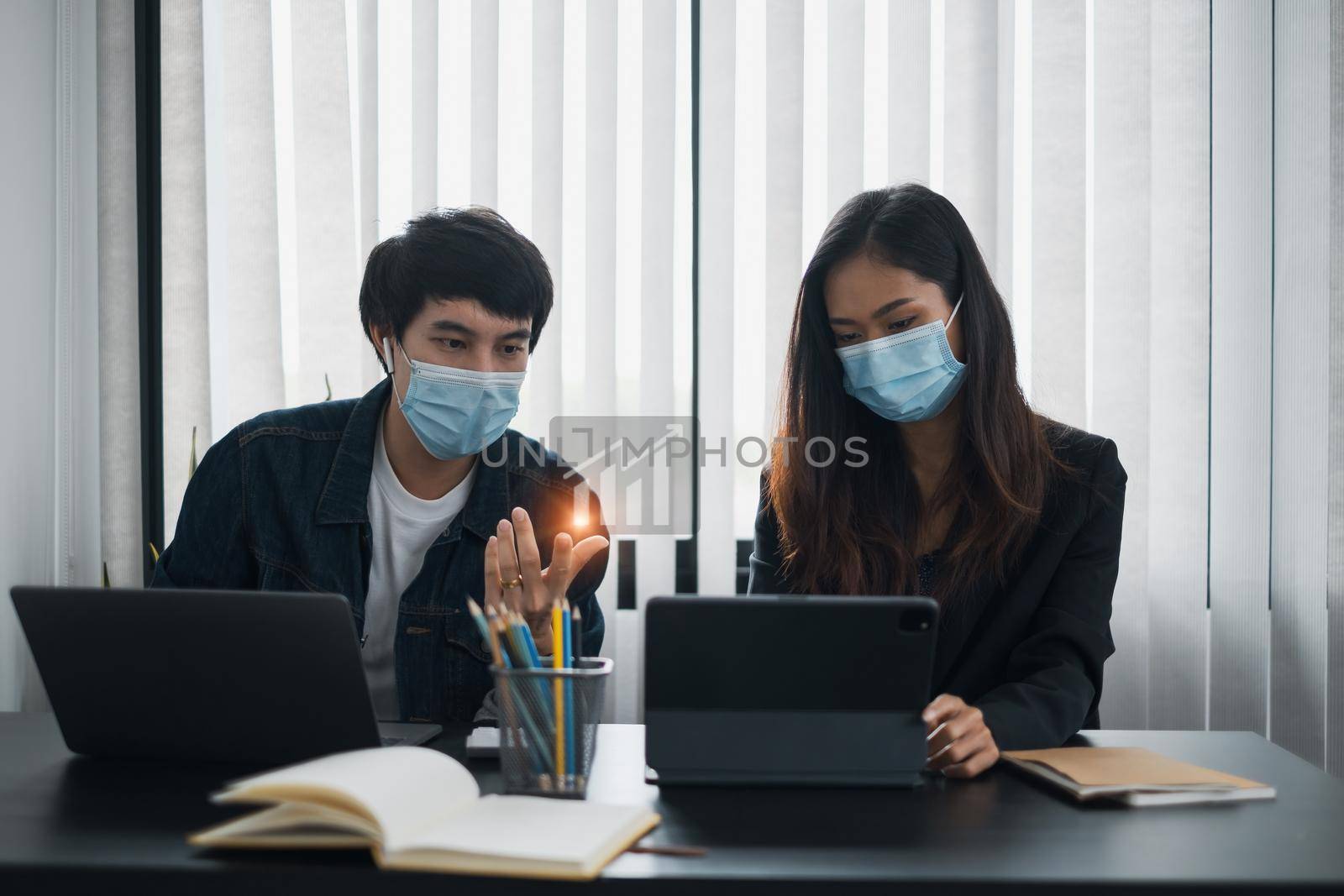 Businessman and team wear mask and try to explain about his work at home office. Work from home concept