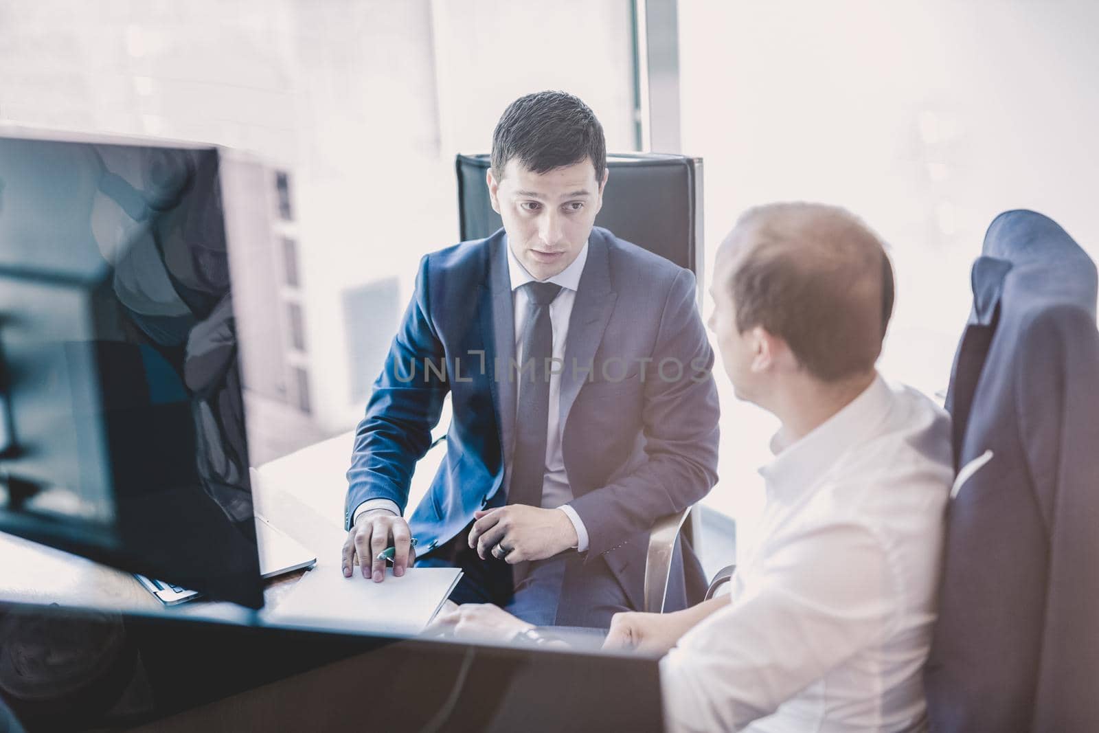 Two businessmen discussing a bisiness problem at meeting in trading office. by kasto