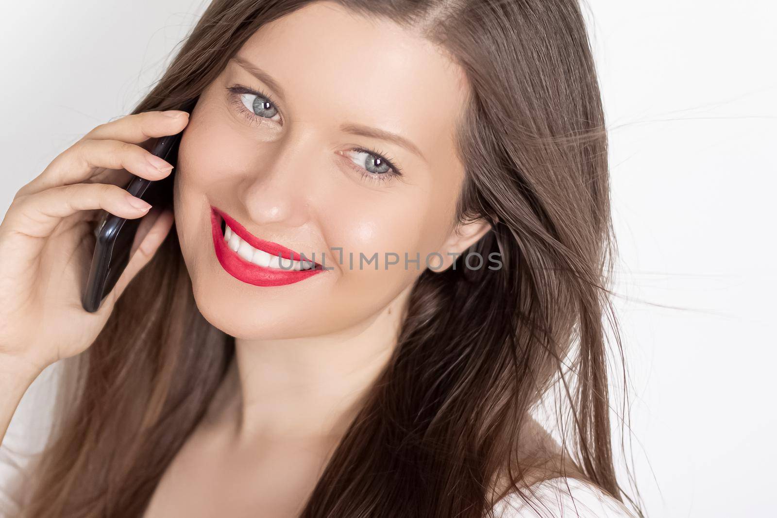 Happy smiling woman calling on smartphone, portrait on white background. People, technology and communication concept.