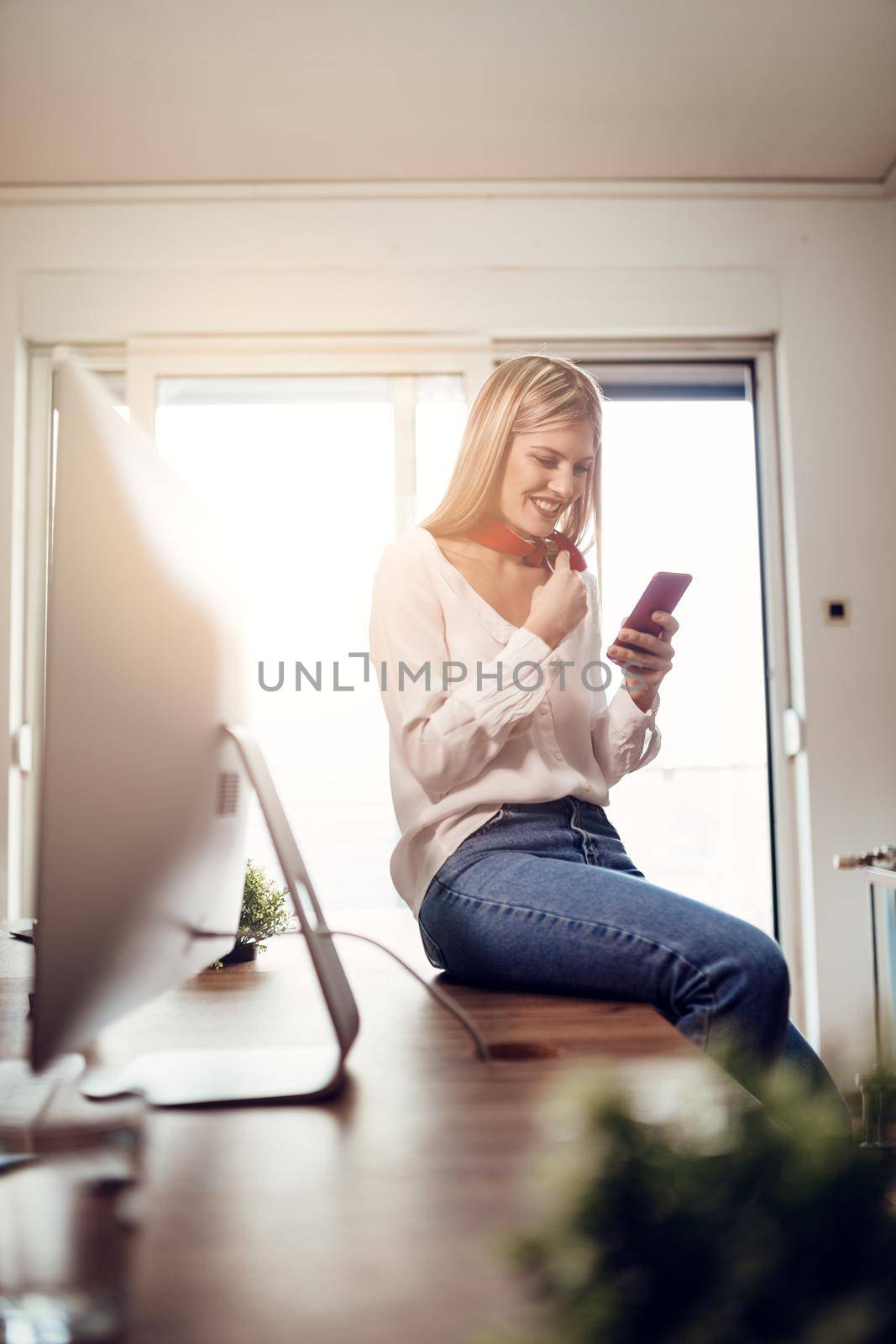 Young happiness female entrepreneur using smart phone at the office.