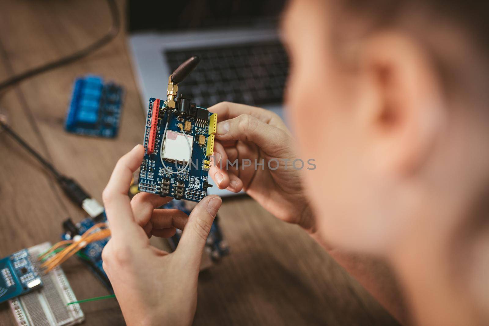 Close-up of a female hands soldering circuit board on the table.