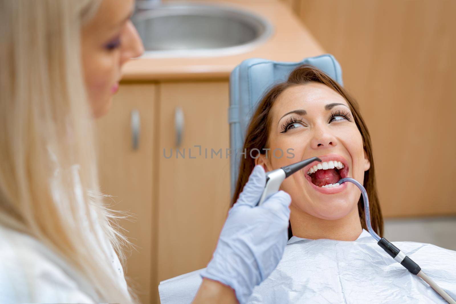 Beautiful young woman in visit at the dentist office and dentist repair her teeth. 