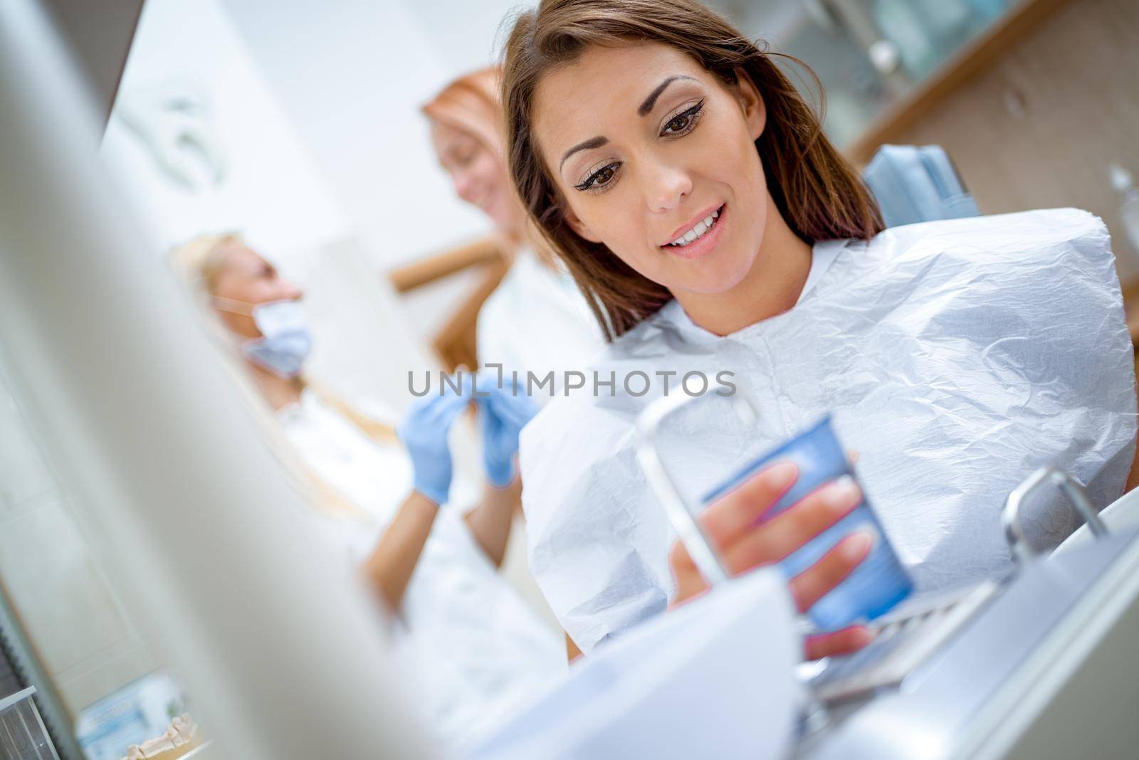 Beautiful young woman in visit at the dentist office preparing for checking up her teeths.
