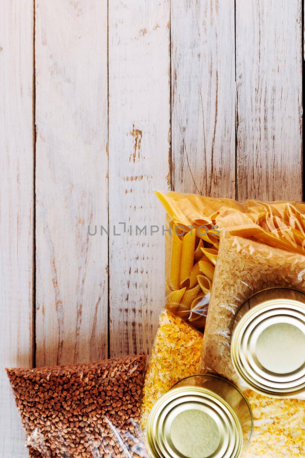 Food supplies quarantine food crisis isolated on white wooden background. Rice, pasta, corn flakes, buckwheat, canned food. Concept of food delivery, donation, charity. Copyspace.