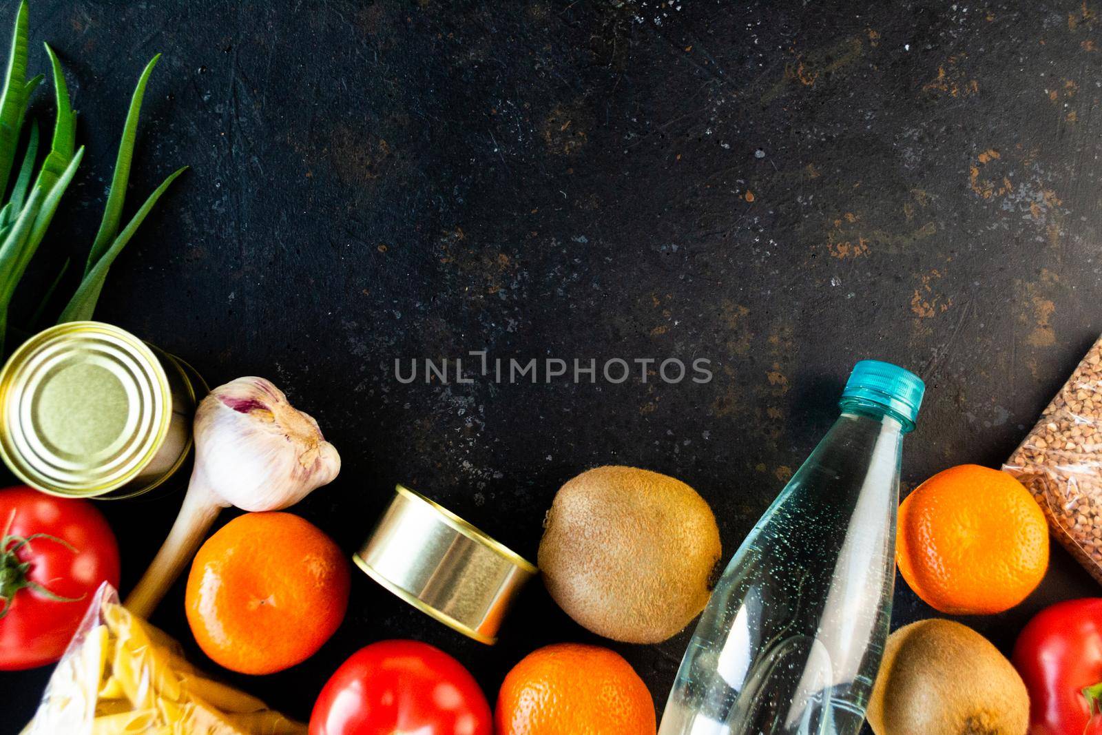 Food supply quarantine food crisis isolated on black concrete background. Cereals, canned food, pasta, fruits, vegetables, water. The concept of food delivery, donation, charity. Copyspace.flat lay