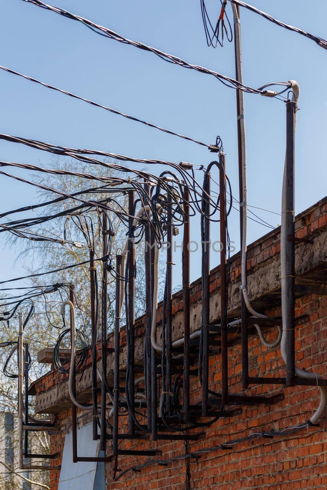 lots of wires sticking out of an old brick electrical substation building at daylight