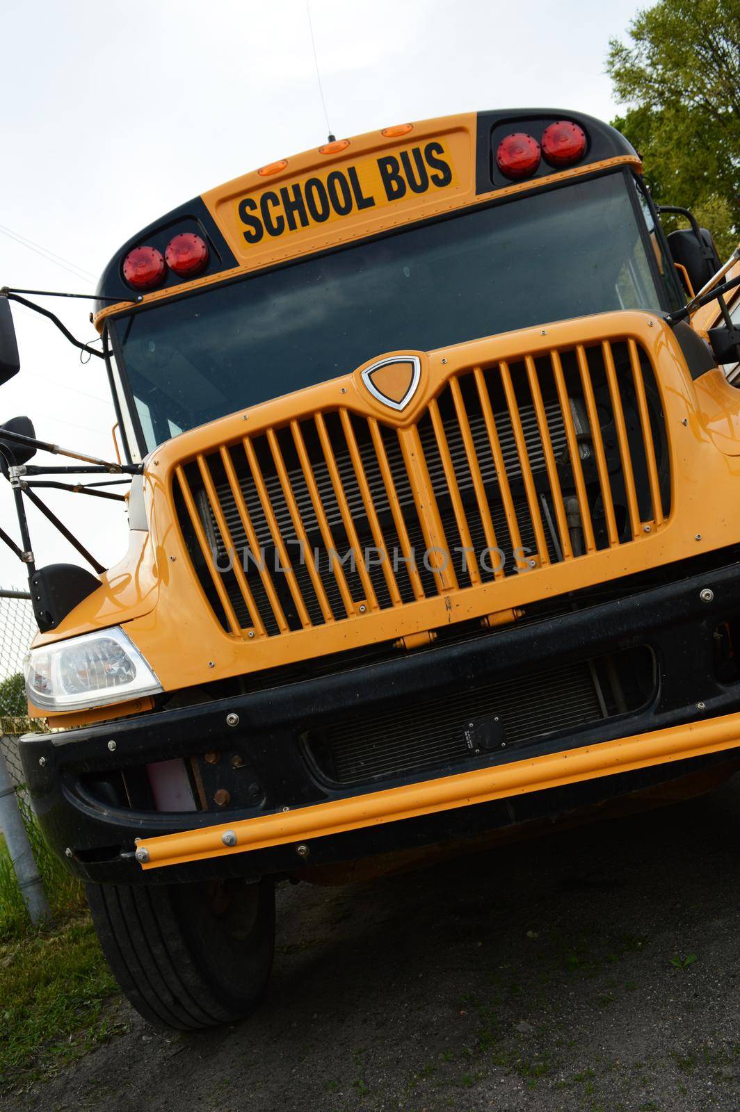A low angle school bus shot from the front during the daytime.