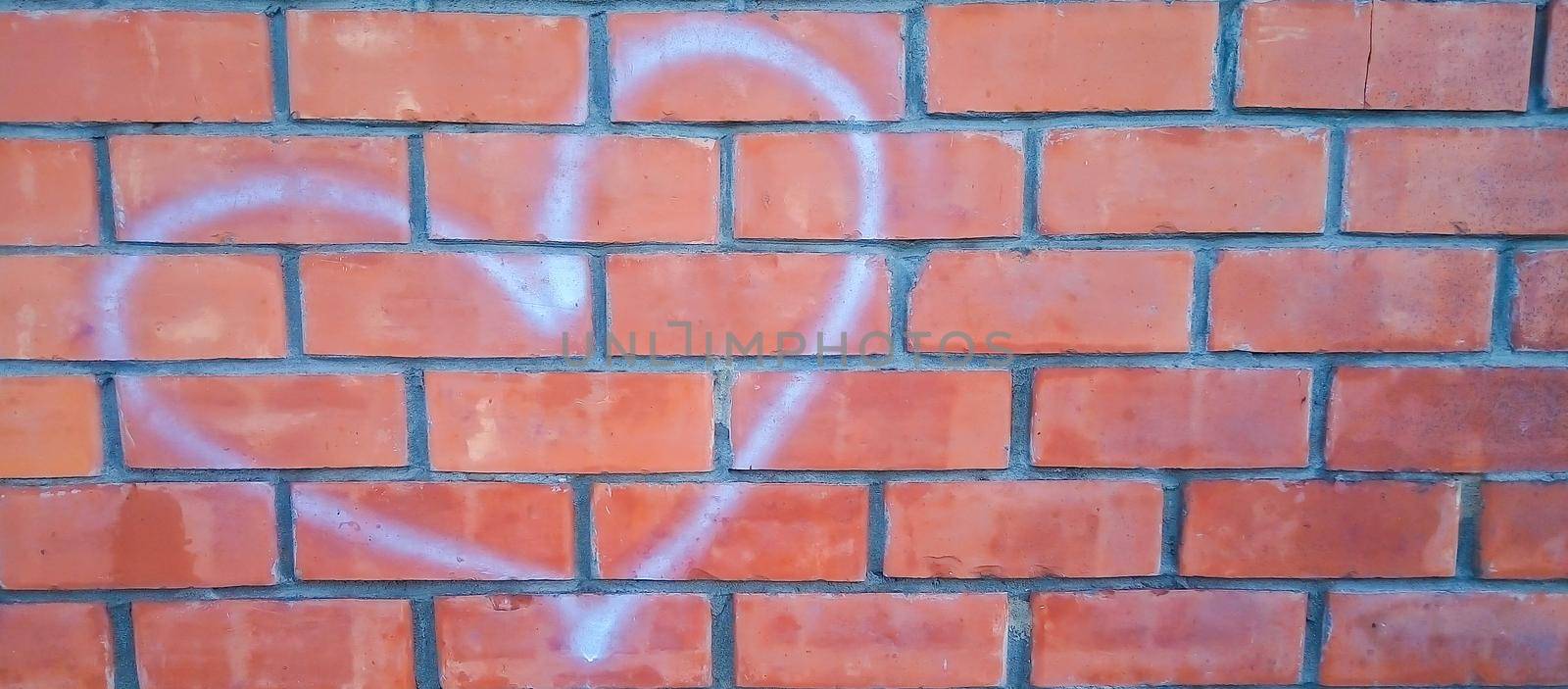 Red brick wall with white heart-shaped outlines.