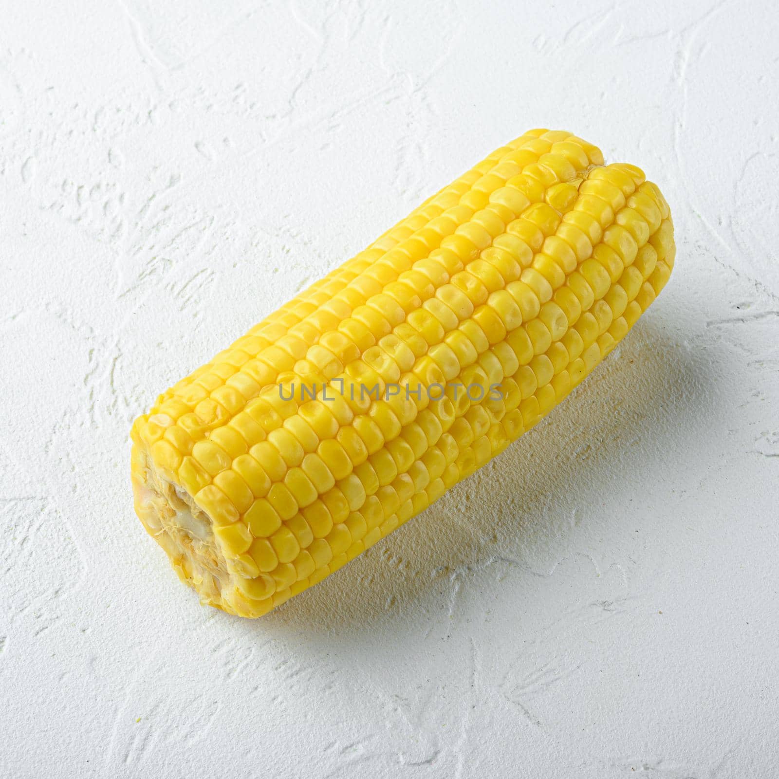 Boiled corn slices, on white stone background, square format by Ilianesolenyi