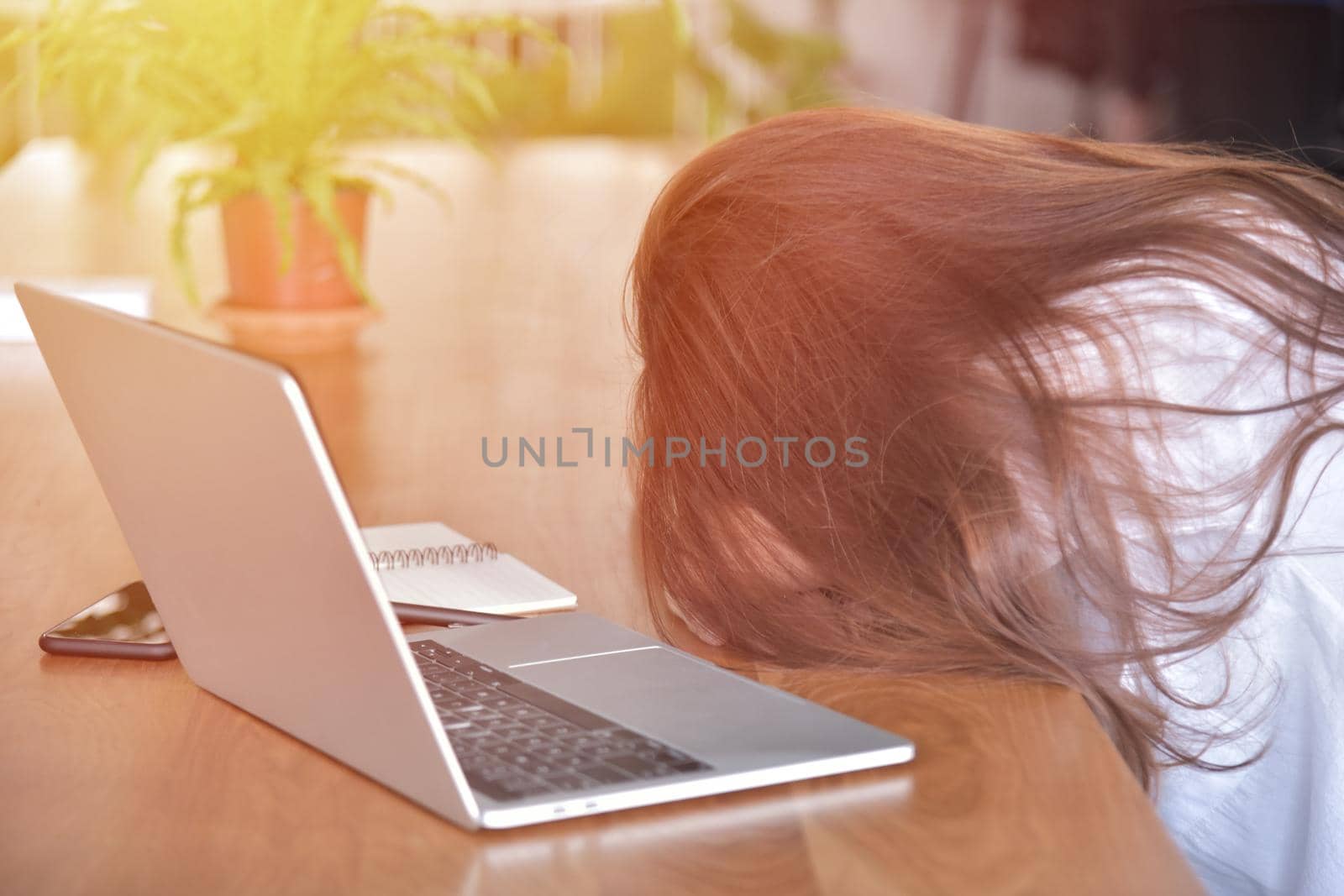 Tired woman sleeping on her desk at the workplace