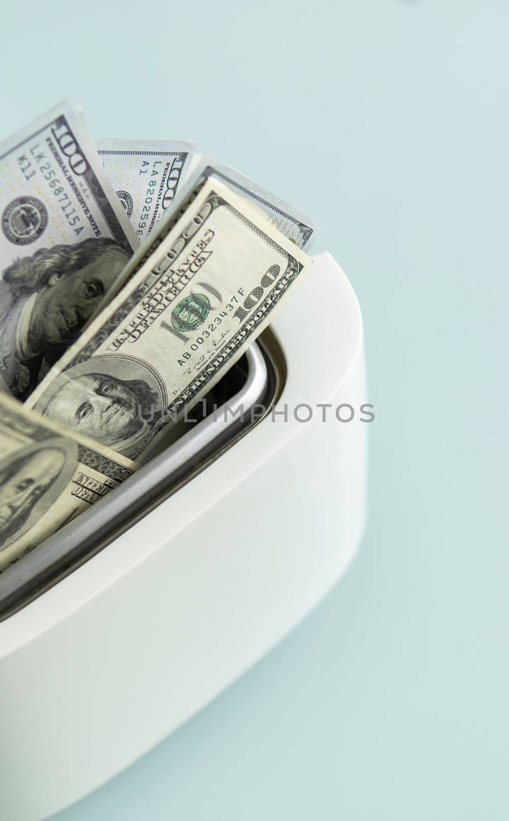 US Hundred dollar bills burning in the toaster. US dollars roasting in toaster. Financial concept. by vovsht