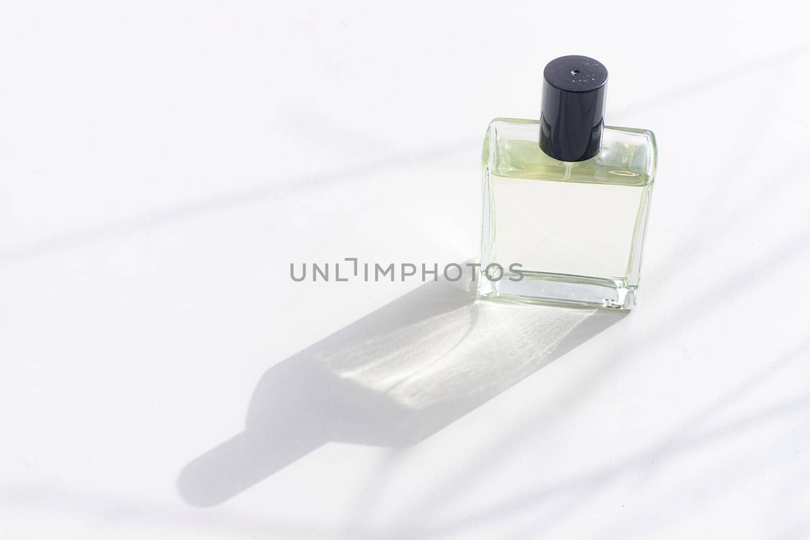 Perfume on a white background with shadows . The choice of perfume. Aromatherapy. Smell. A bottle of perfume. White background. Light and shadows . Copy space
