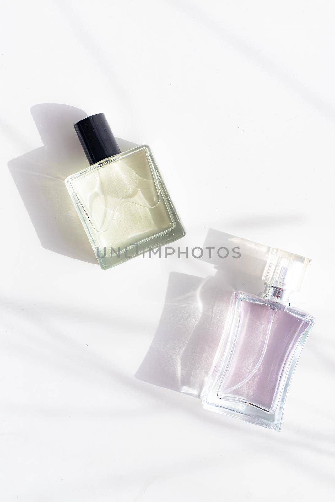 Perfume on a white background with shadows . The choice of perfume. Aromatherapy. Smell. A bottle of perfume. White background. Light and shadows . Copy space