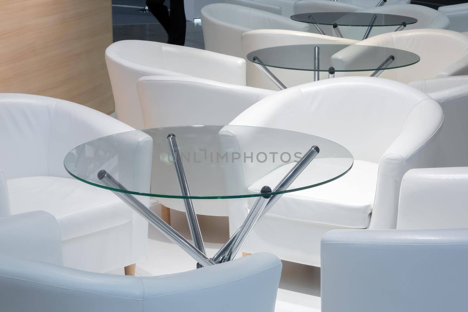 White leather comfortable chairs and a glass table in the office meeting area