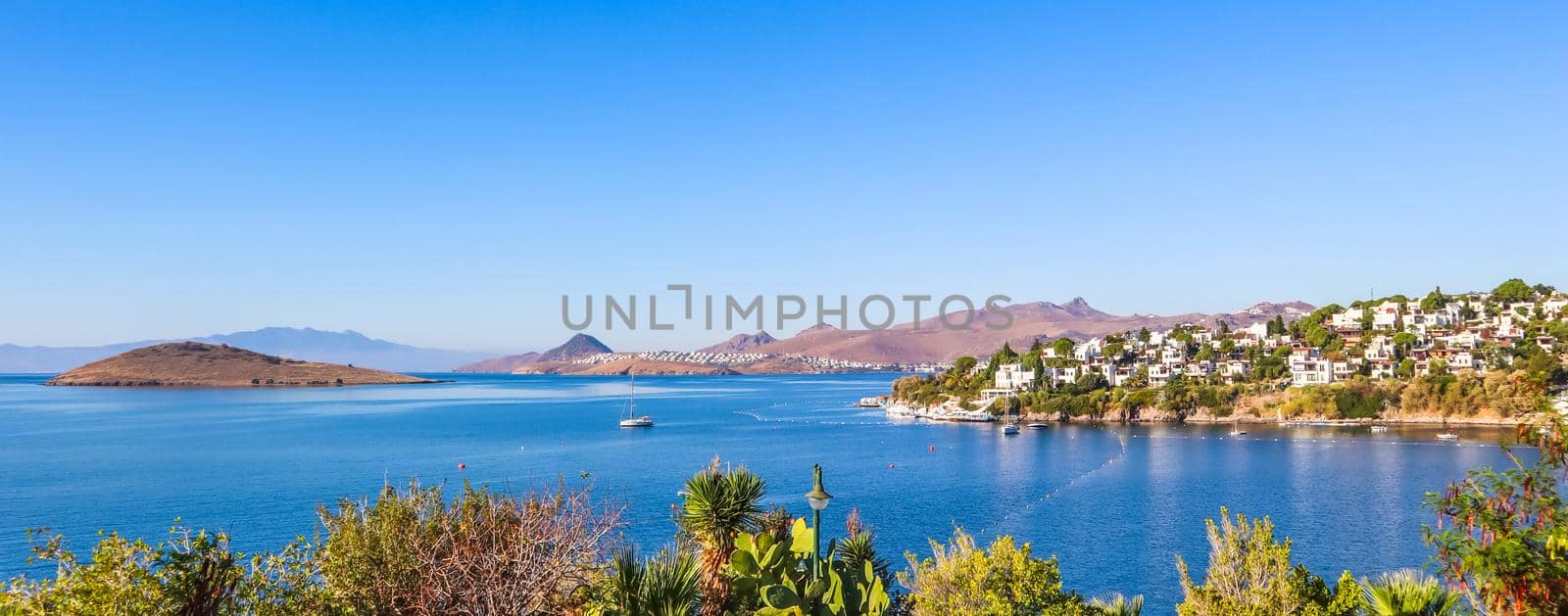 A tourist photographs a lovely view of beautiful bay with calm blue water. Rest and relaxation on the sea coast
