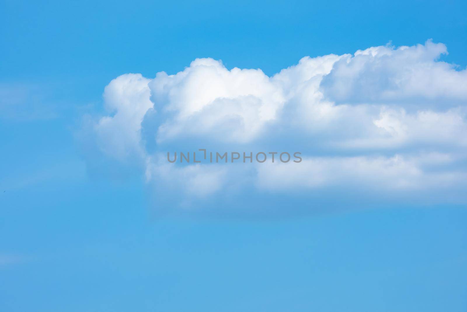 White cumulus clouds on a blue sky background