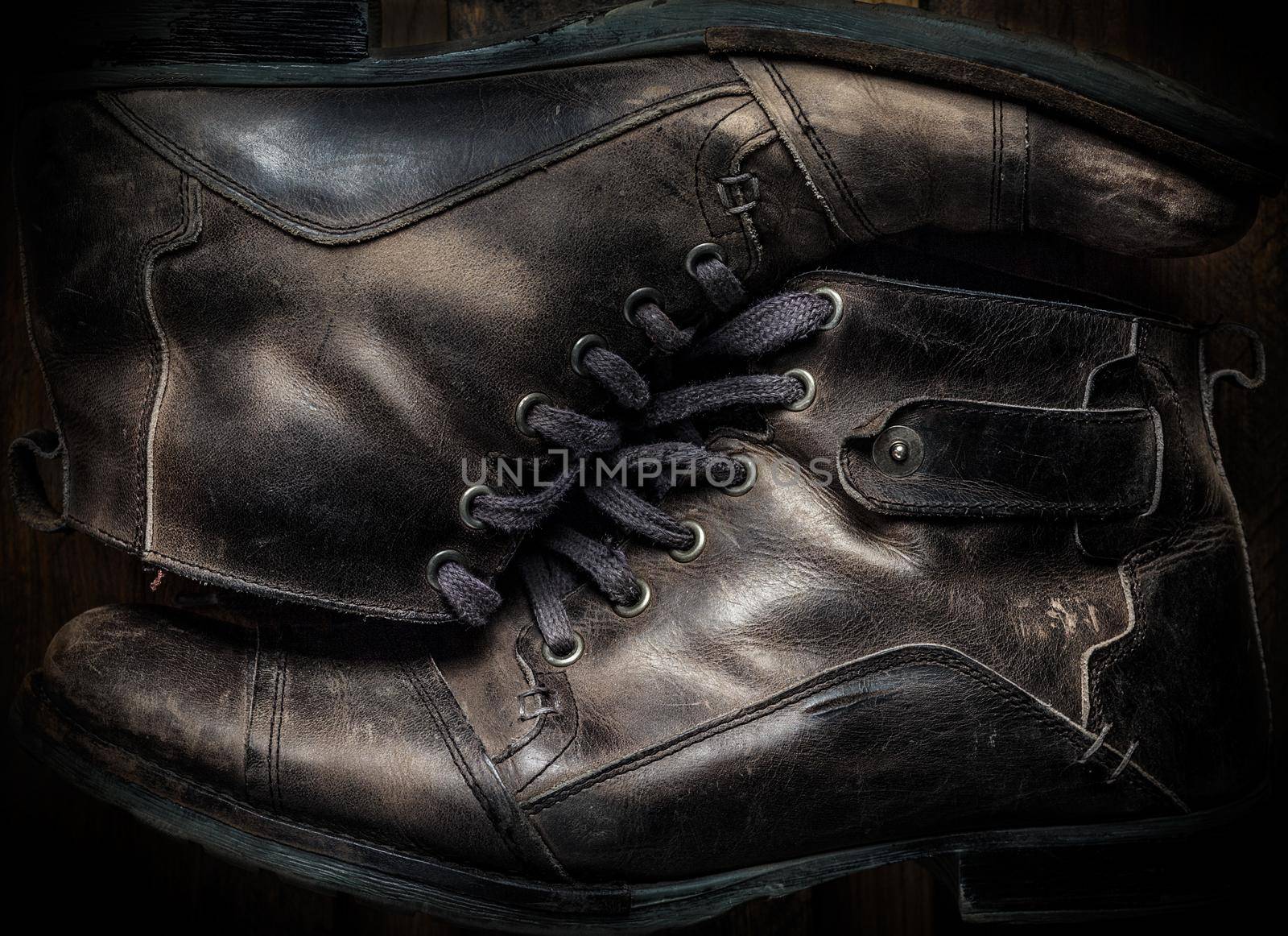Casual gray leather shoes for men on wooden board.  Dark mood style. Top view. Horizontal  image