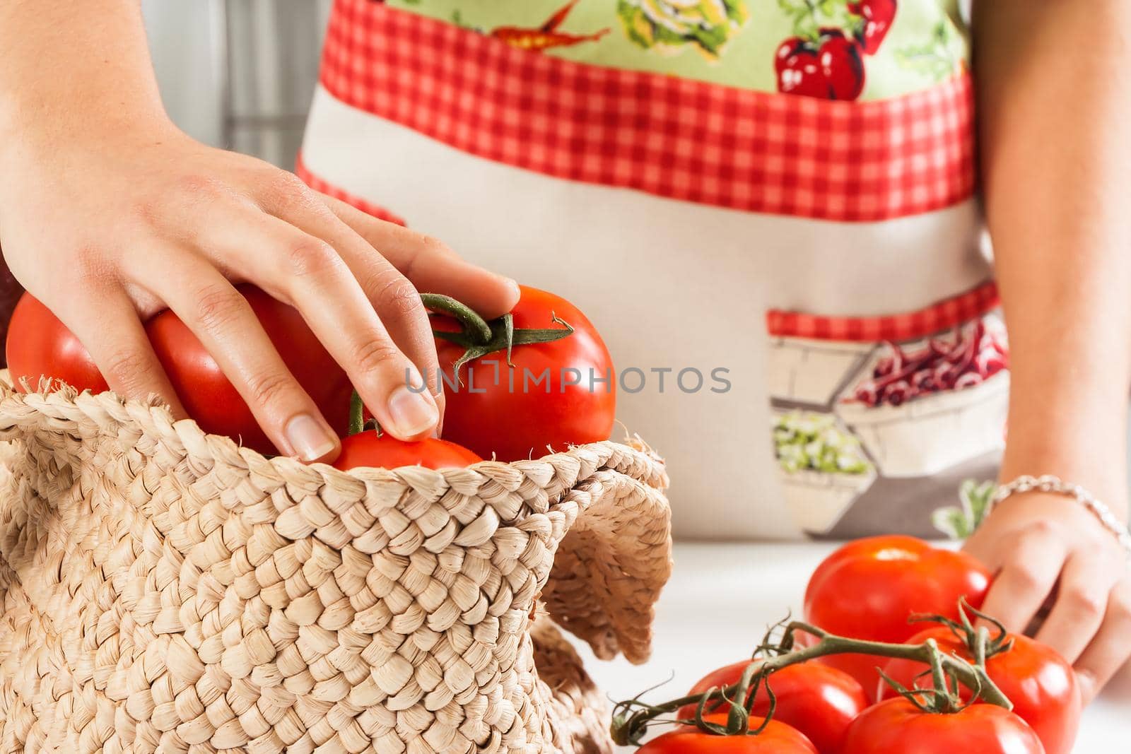 Woman with an apron picking tomatoes