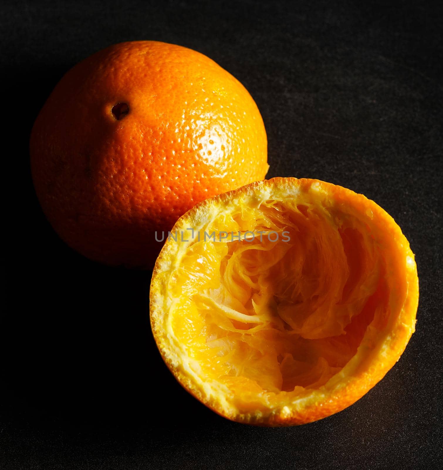 Used orange skins with dramatic light on black background. Square image.