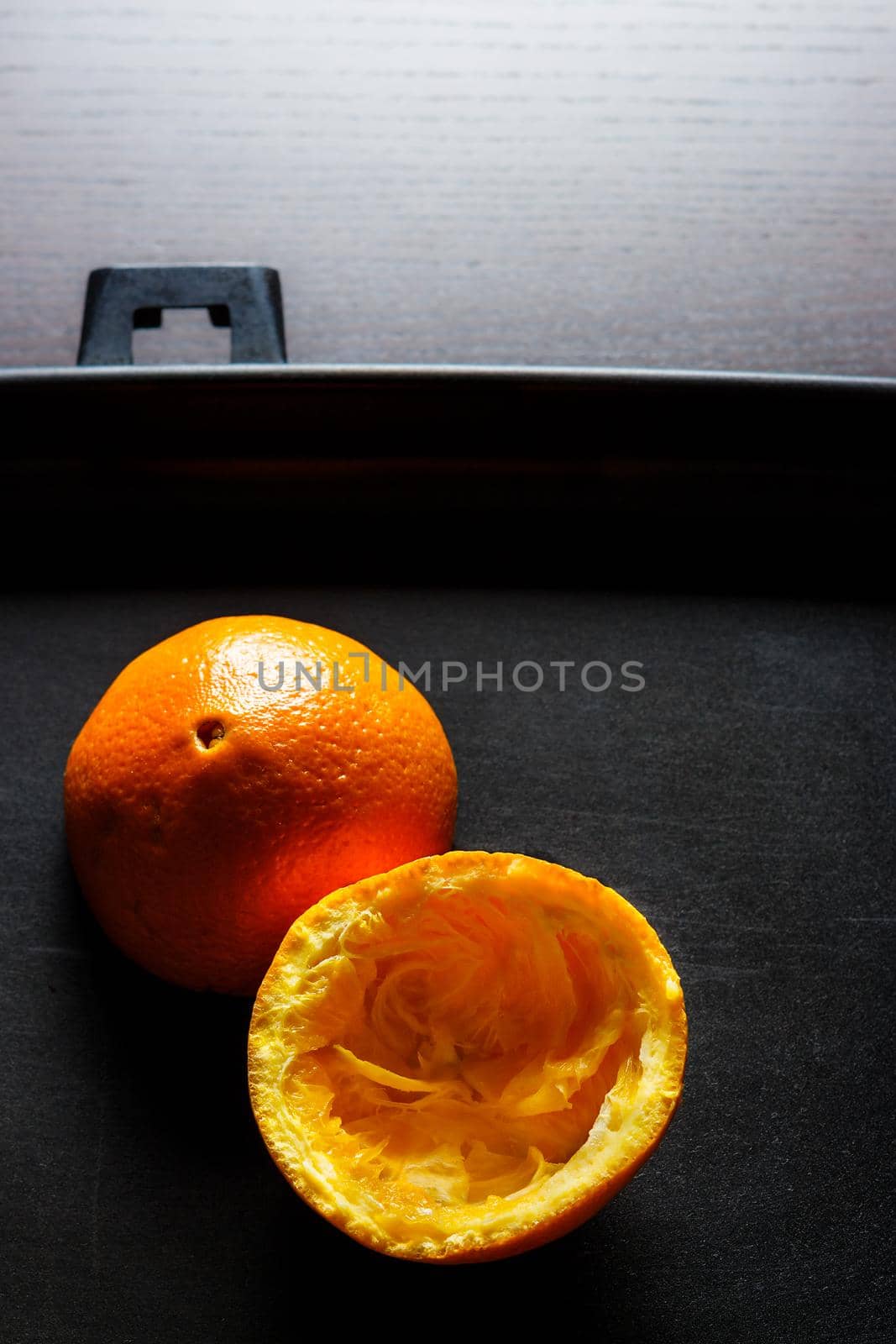 Used orange skins with dramatic light on black background. Vertical image.