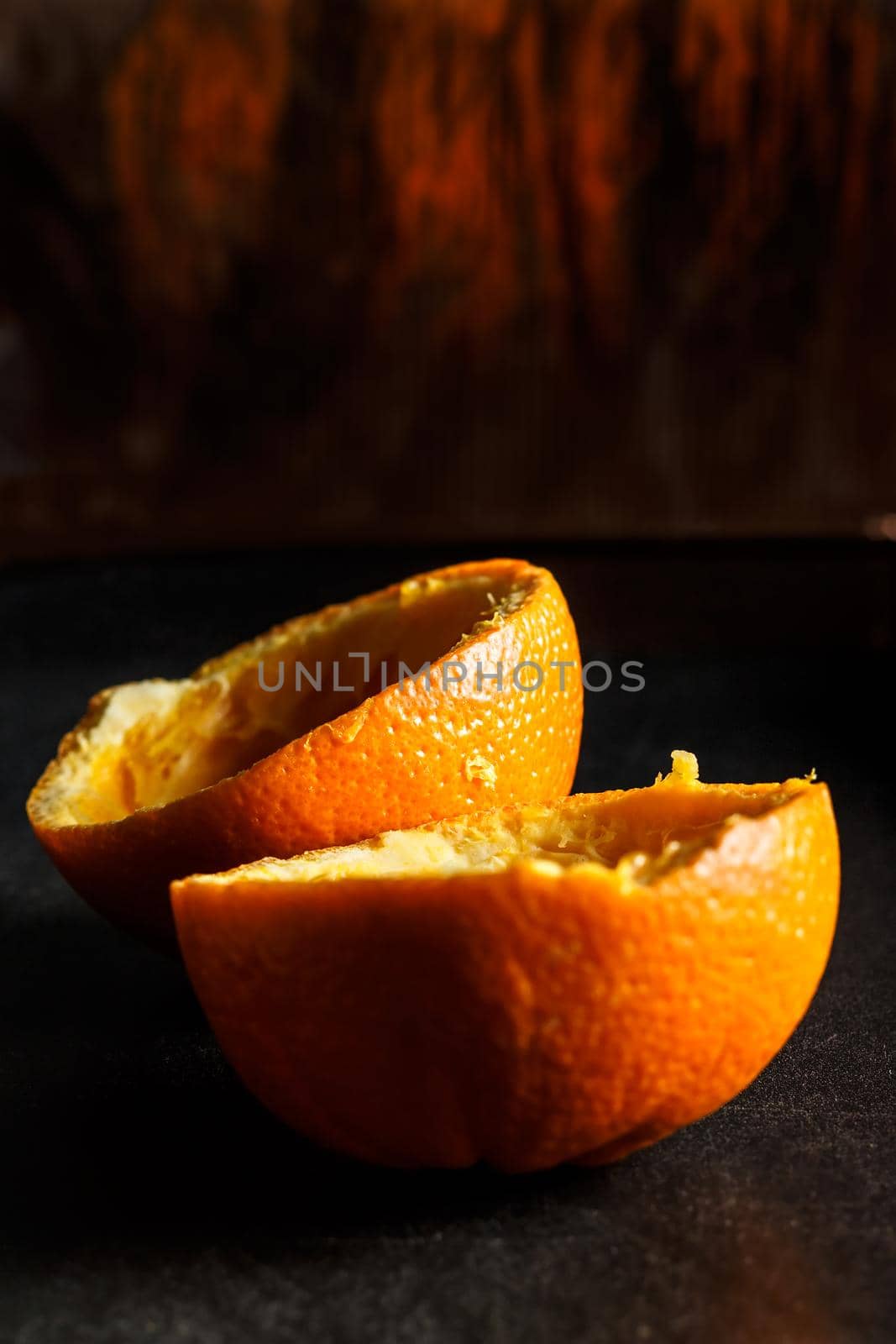 Used orange skins with dramatic light on black background. Vertical image.