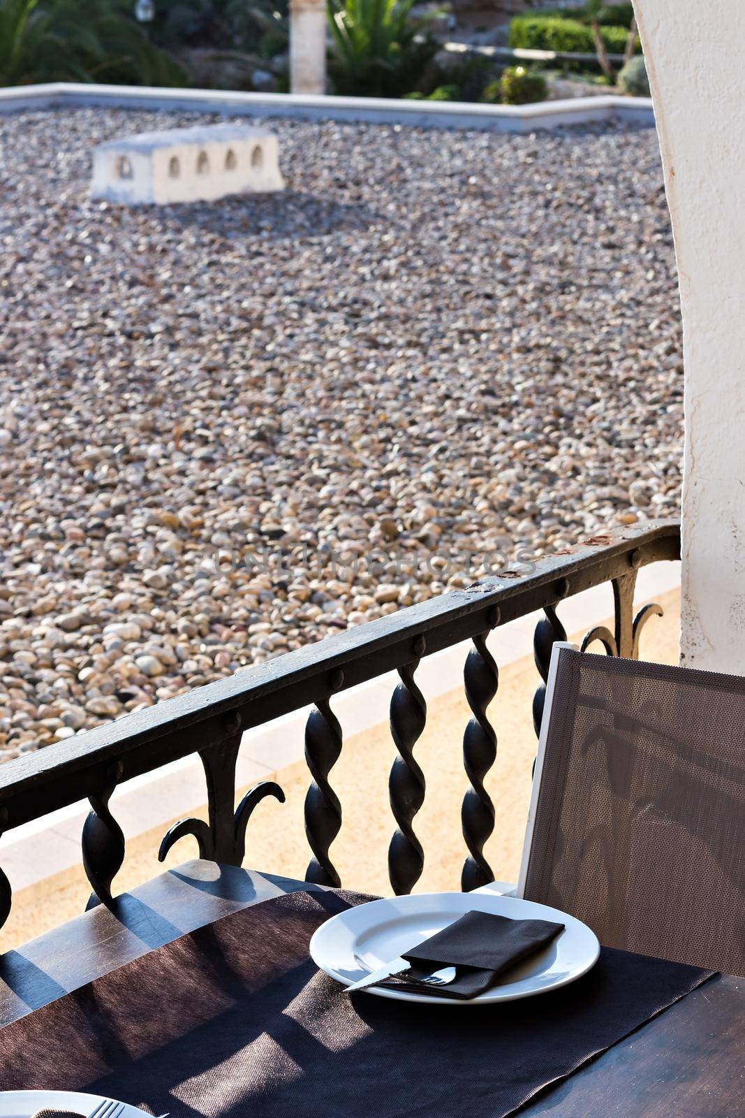 Restaurant table with plate and cutlery in front of a terrace. Holidays. Relax.