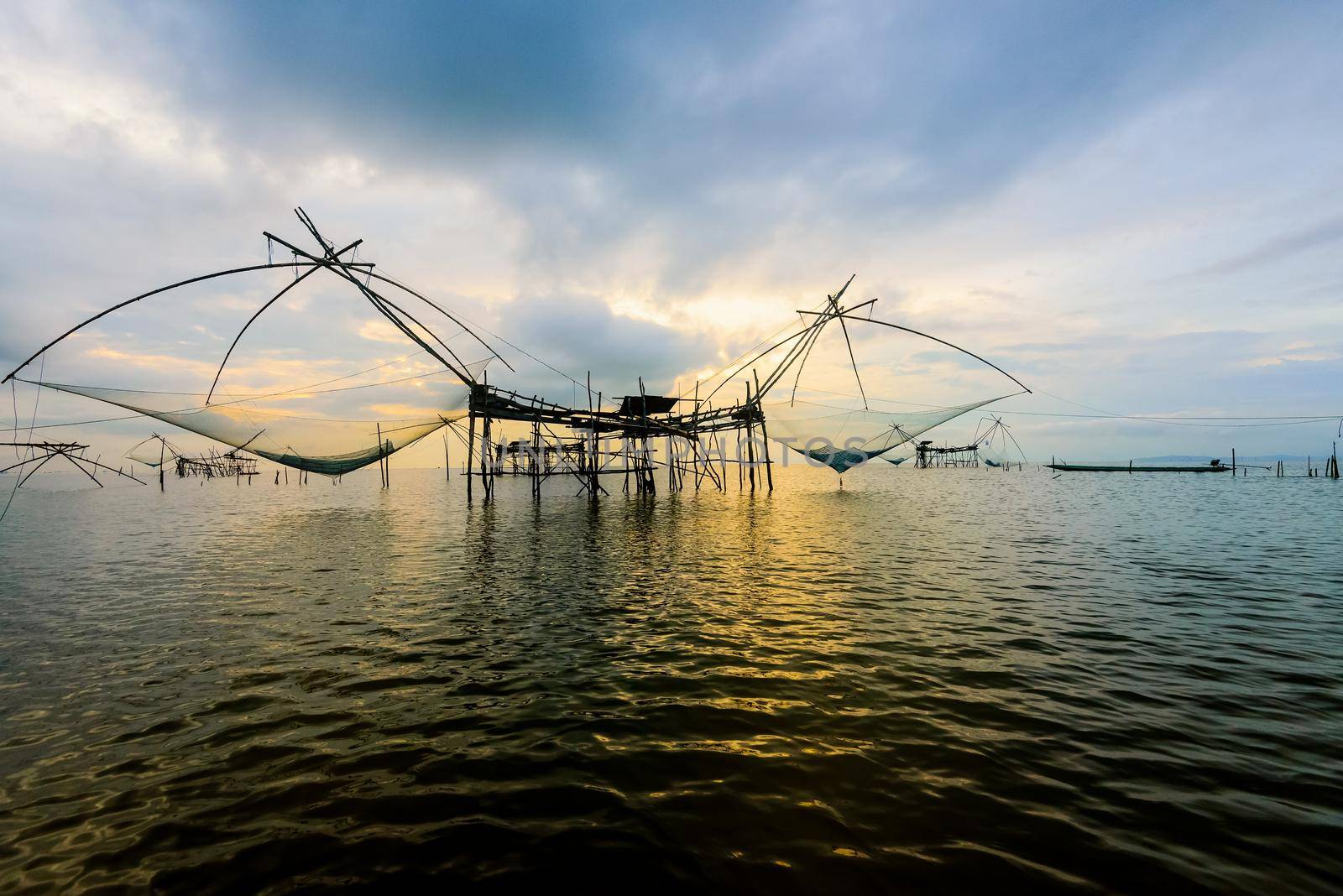 Beautiful nature landscape golden light of the morning sky at sunrise and native fishing tool rural lifestyle at Pakpra canal, Songkhla Lake, Baan Pak Pra is a famous landmark of Phatthalung, Thailand