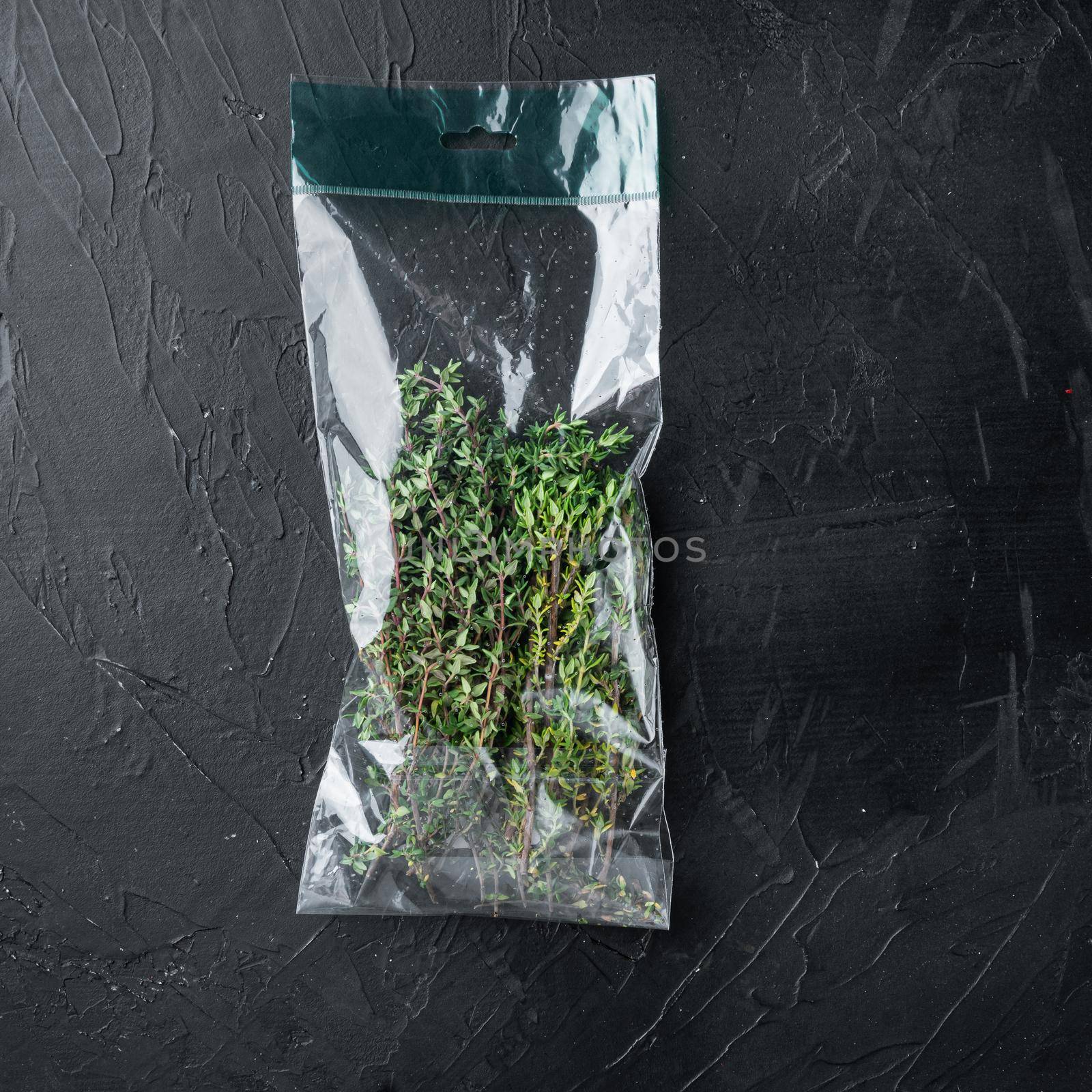 Thyme in plastic bag set, on black background, top view flat lay