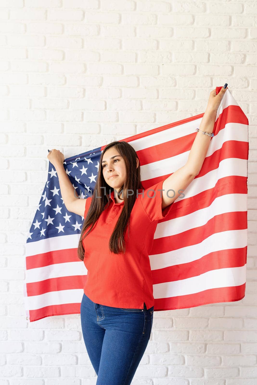 beautiful young woman with american flag, arms outstretched by Desperada