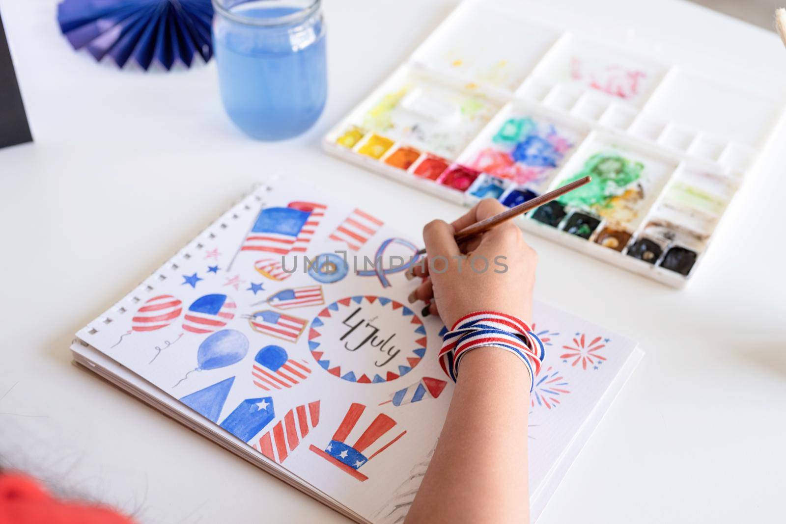 Independence day of the USA. Happy July 4th. Beautiful woman drawing a watercolor illustration for Independence day of the USA