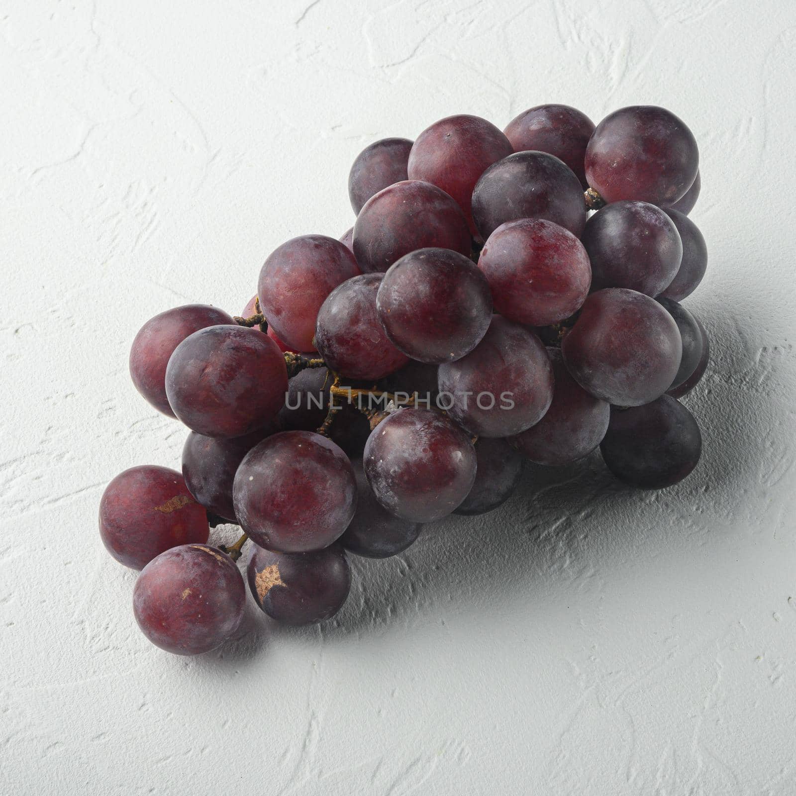 Ripe grape set, dark red fruits, square format, on white stone background