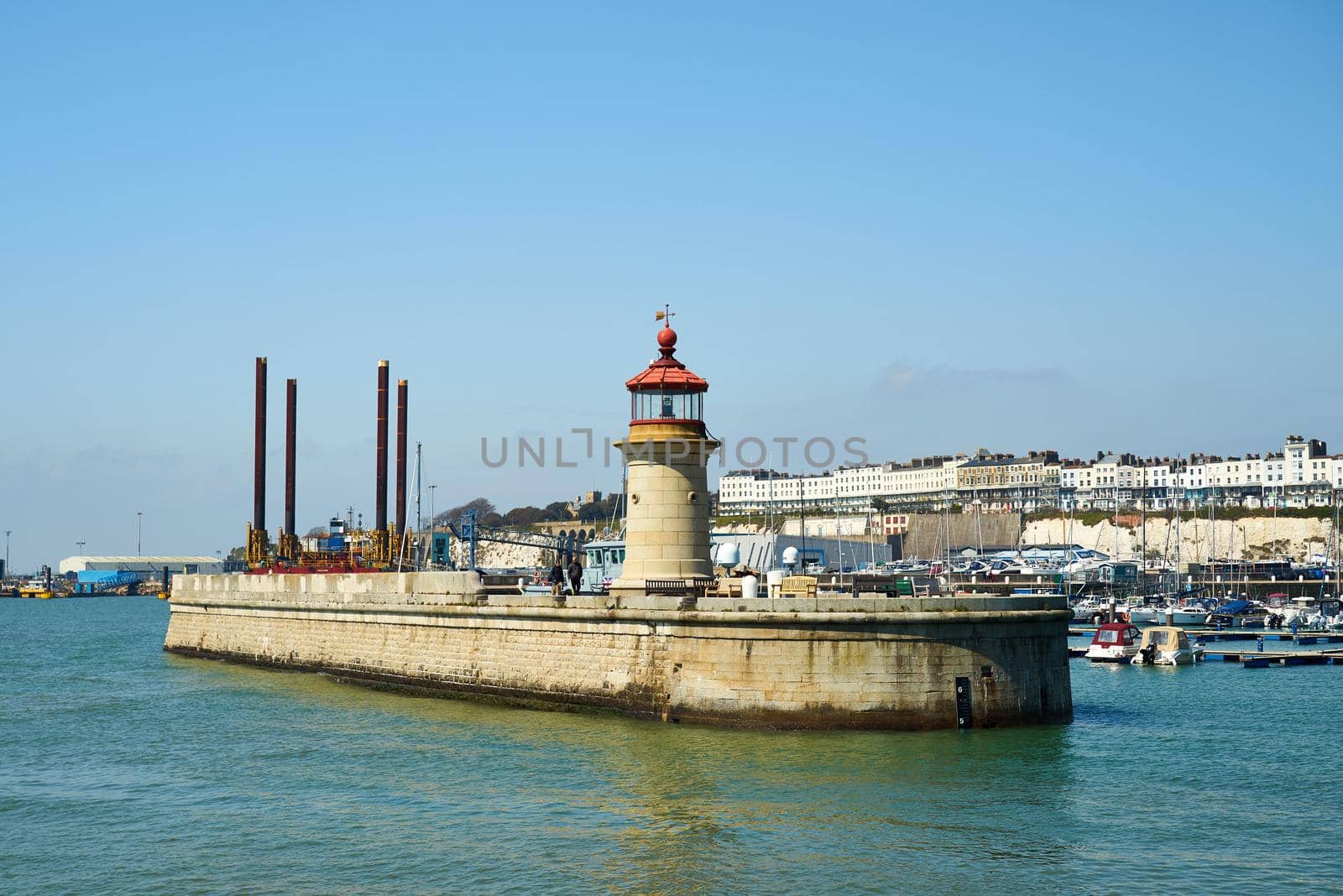 Ramsgate, United Kingdom - April 27, 2021: Ramsgate Lighthouse as viewed from the East Pier with the port and main harbour in the background. by ChrisWestPhoto