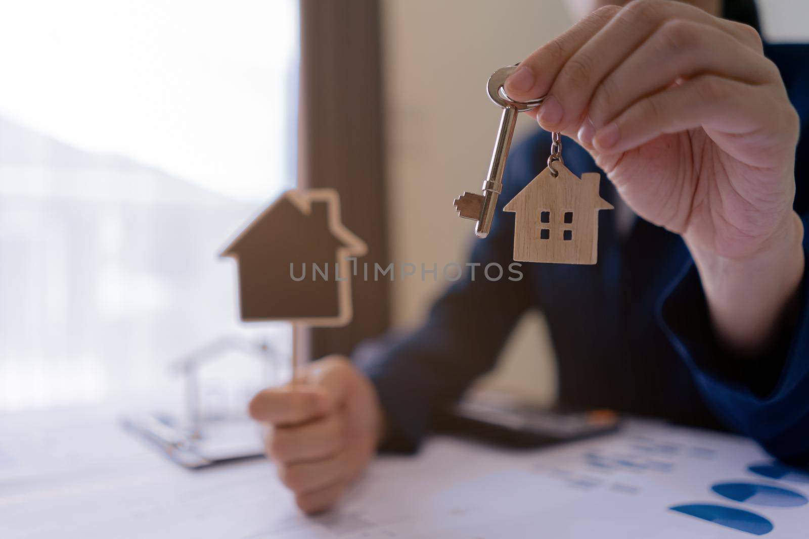 Real estate agent sales manager holding keys to customer and holding sign house offer for and house insurance.home owner, rental property purchase, mortgage investment loan, ownership concept. by pravinrus