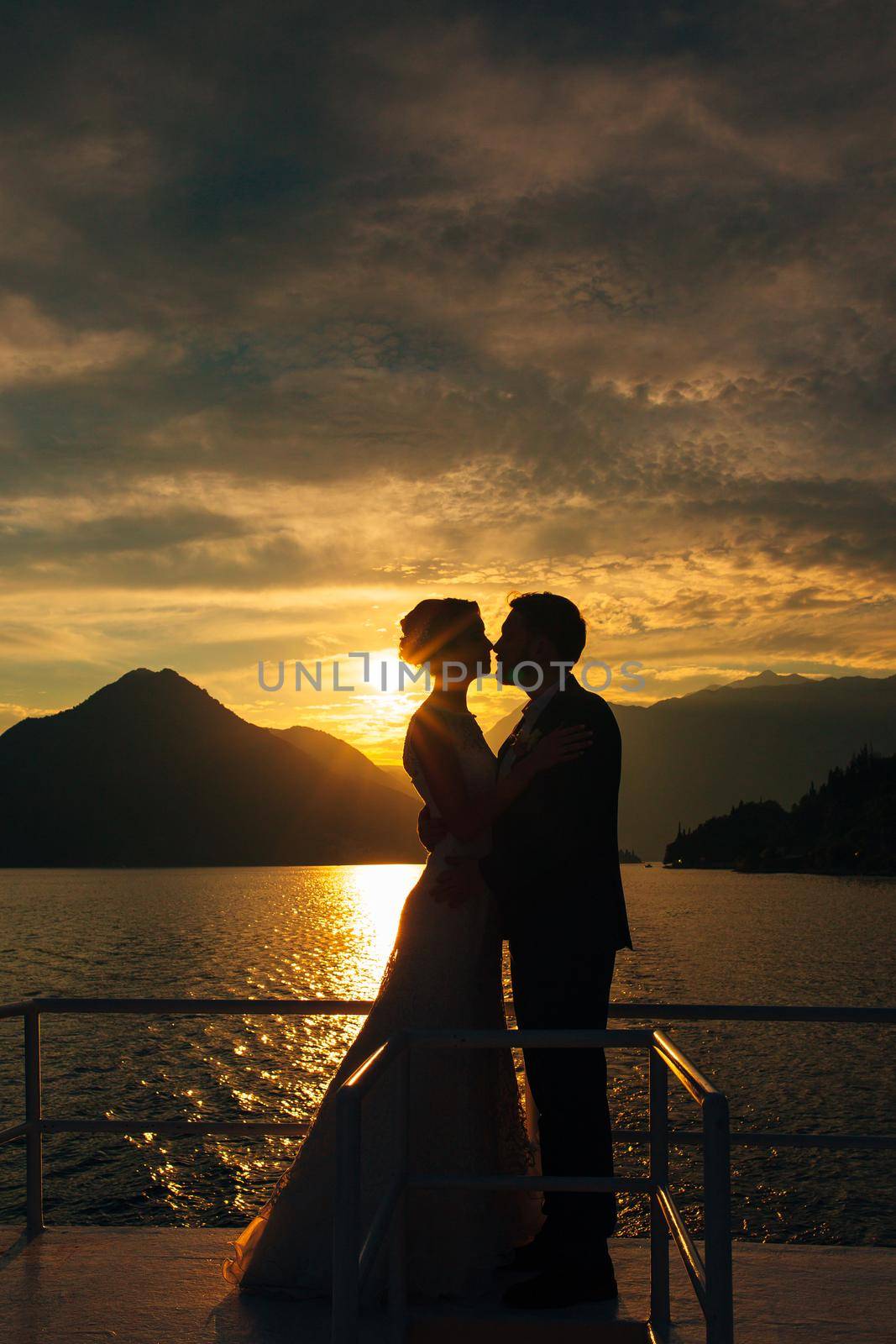 Silhouette of a newlywed couple on the background of the setting sun on the sea in Montenegro.