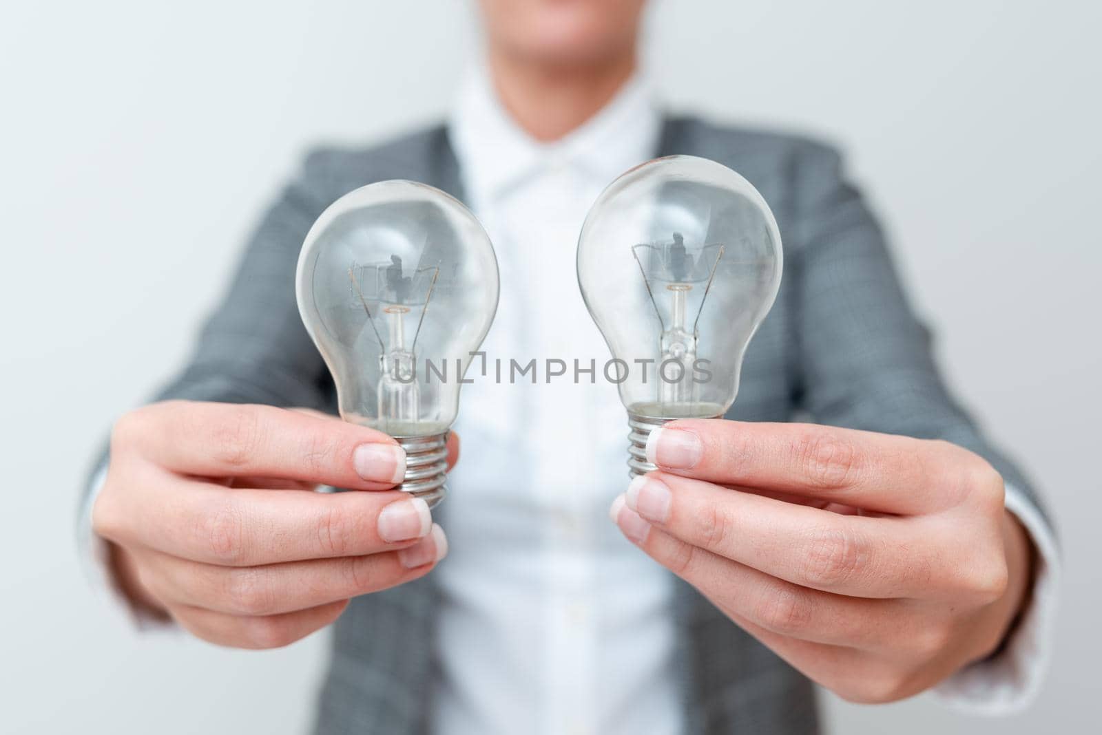 Lady Carrying Two Lightbulbs In Hands With Formal Outfit Presenting Another Ideas For Project, Business Woman Holding 2 Lamps Showing Late Technologies, Lighbulb Exhibiting Fresh Openion.