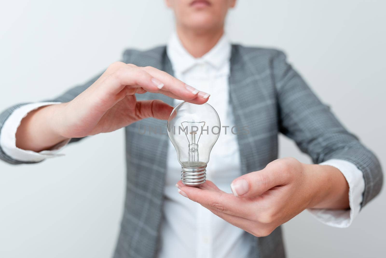 Lady Carrying Lightbulb With Two Hands In Formal Outfit Presenting New Ideas For Project, Business Woman Holding Bulbs In Hands Showing Late Technologies, Lamp Exhibiting Fresh Opinion by nialowwa