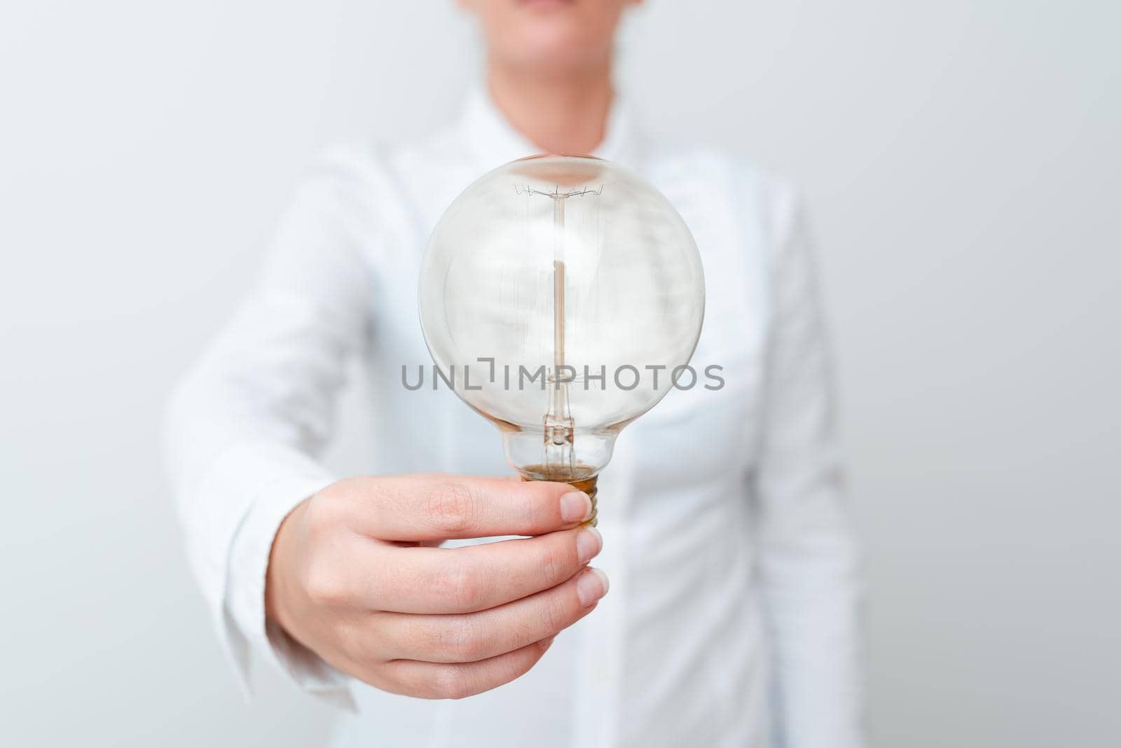 Lady Holding Lamp With Formal Outfit Presenting New Ideas For Project, Business Woman Showing Bulb With One Hand Exhibiting New Technologies, Lightbulb Presenting Another Openion by nialowwa