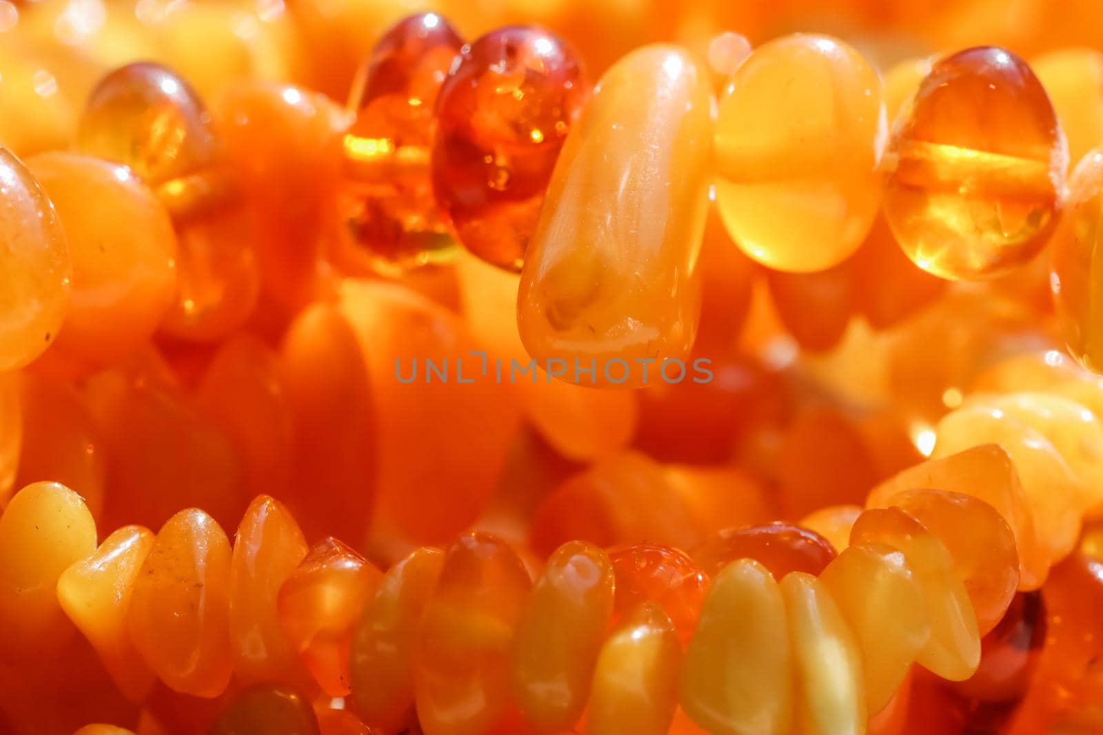 Sunny beads of fire amber. Natural gemstone background, jewelry concept