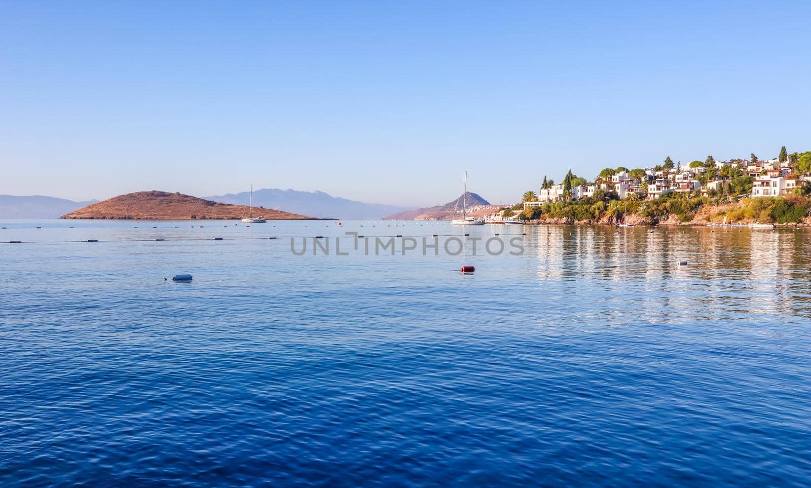 Aegean coast with marvelous blue water, rich nature, islands, mountains and small white houses by Olayola