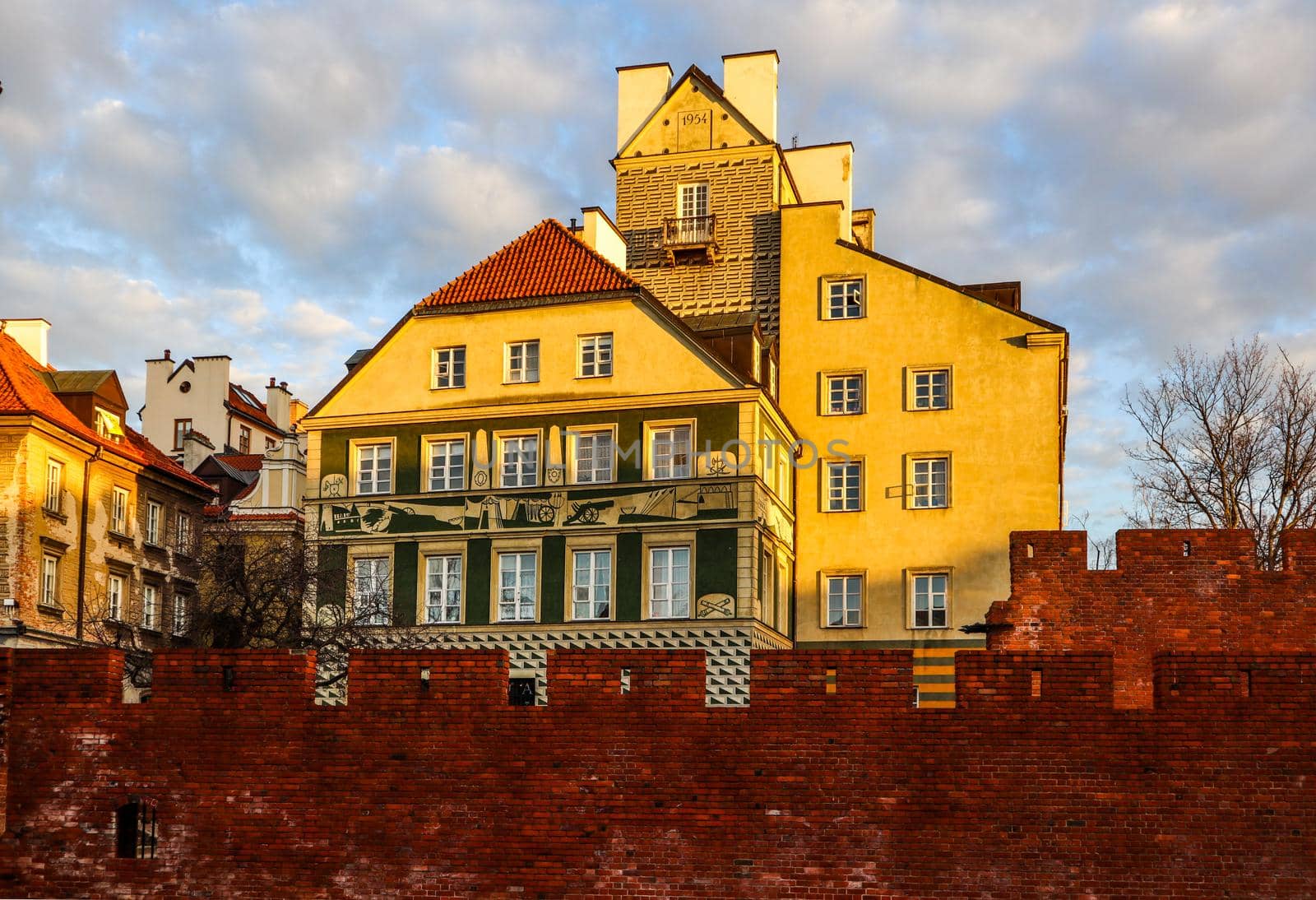 Historic buildings and red brick walls of Warsaw Barbican Poland at sunset in spring by Olayola