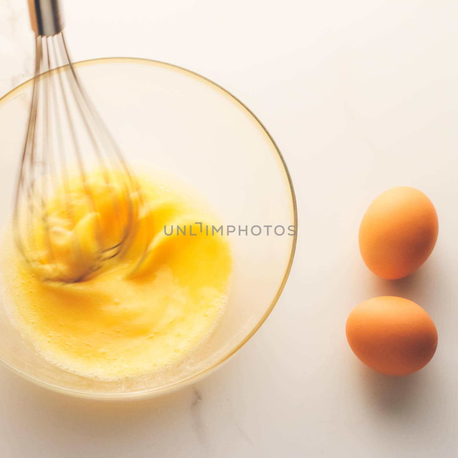Cooking, meal and diet concept - Making of mixing eggs in bowl on marble table as homemade food flat lay, top view food brand photography flatlay and recipe for cooking blog, menu or cookbook design