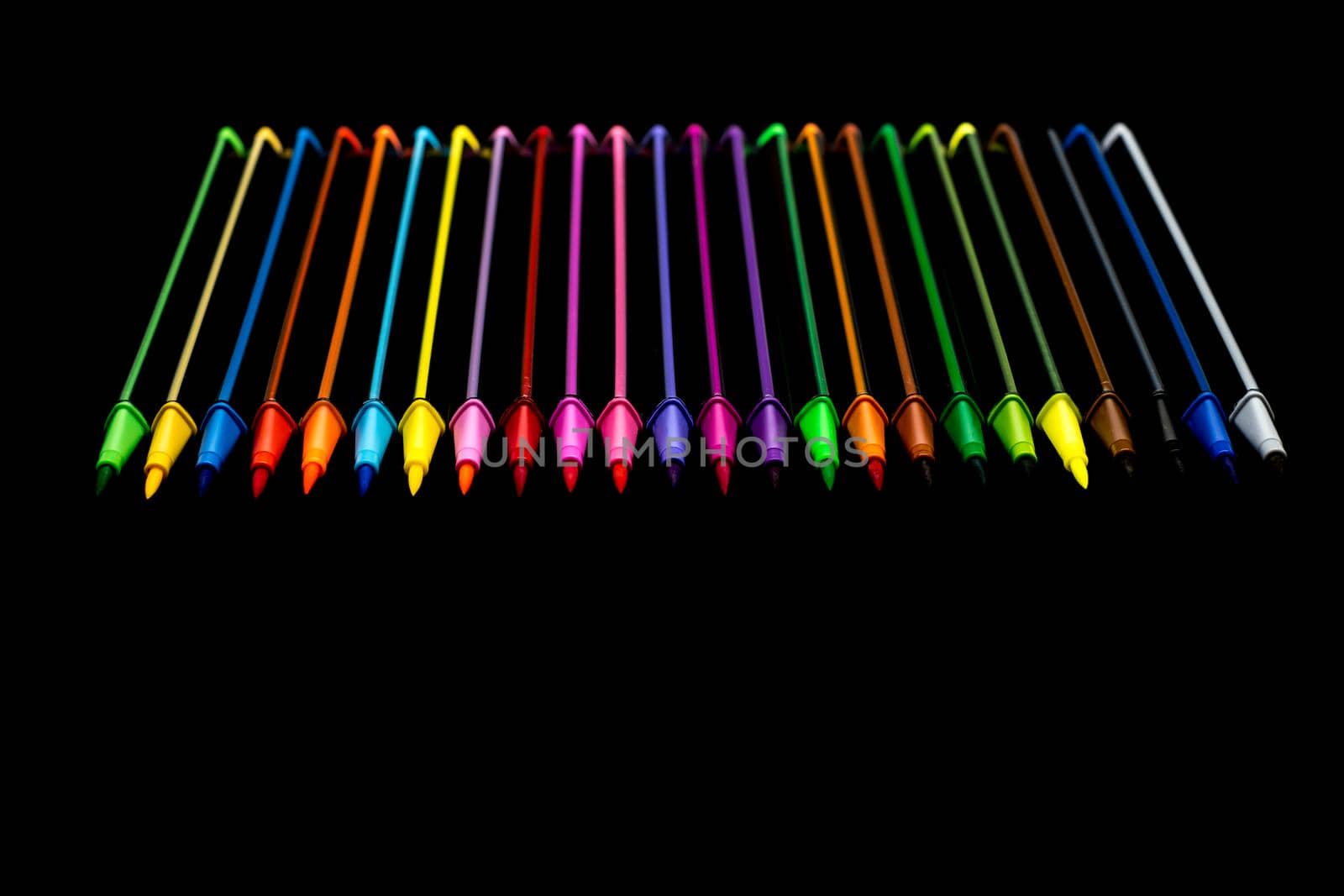 A set of rainbow markers on black background