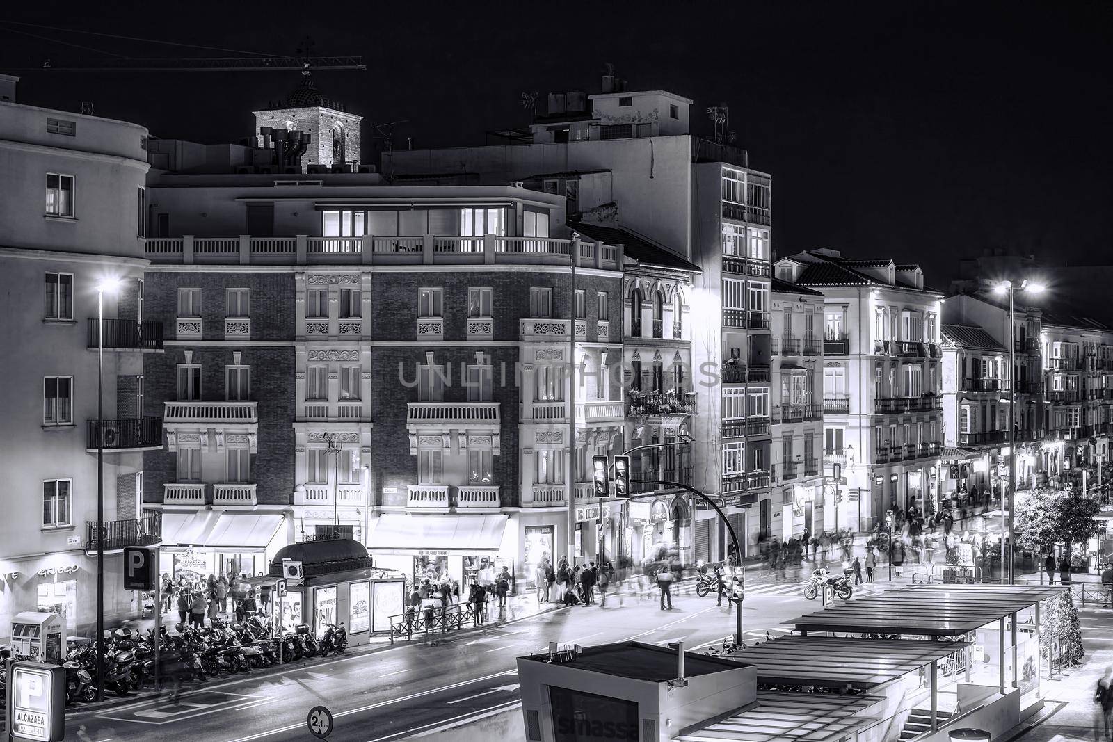 Malaga, Spain - March 29, 2018. People moving in night city street with shopping malls