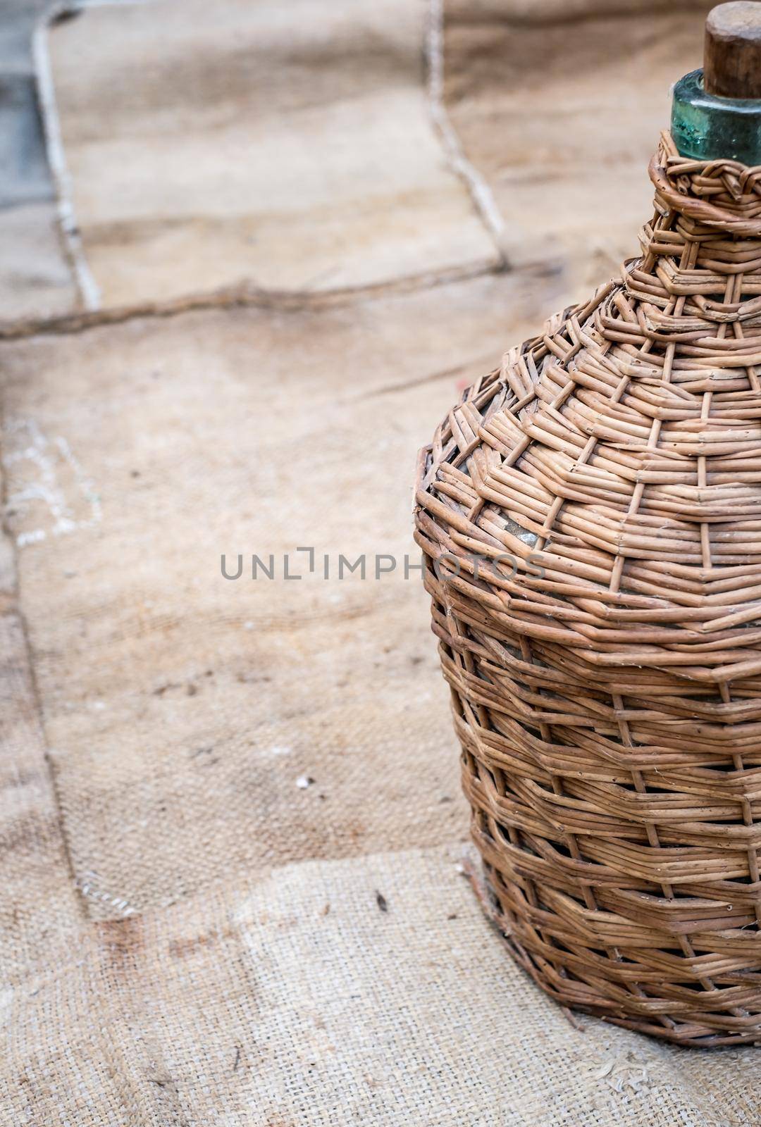 demijohn and old wood wine barrel on jute sack