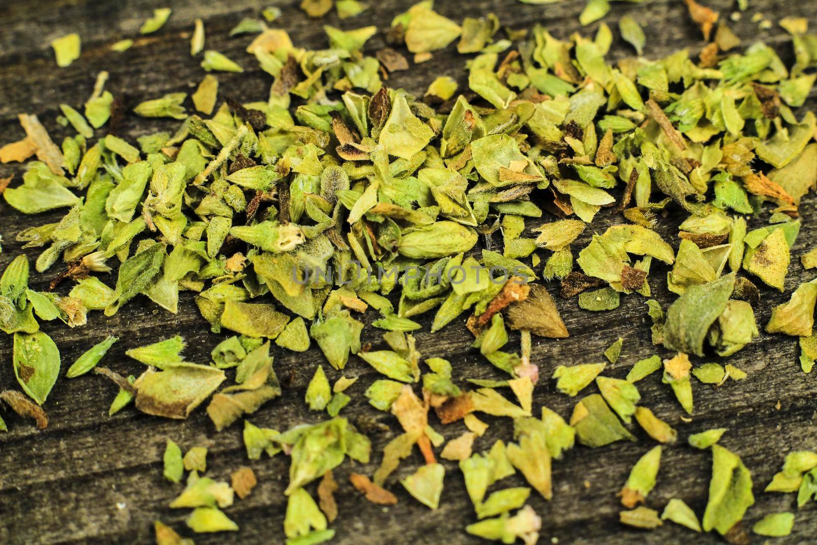 Crushed dried oregano to spice up dishes on gray wooden board